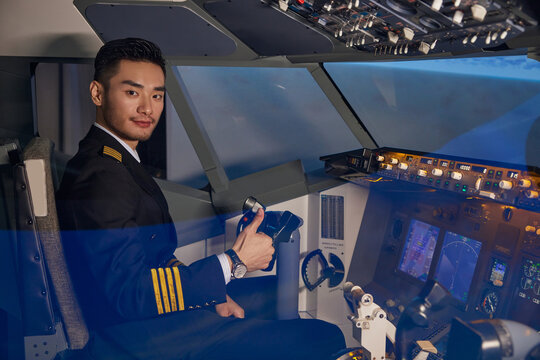 Young male airline pilot in aircraft cockpit