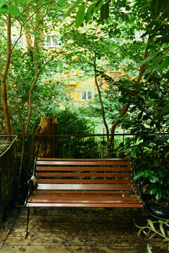 Empty wooden bench on deck in residential courtyard