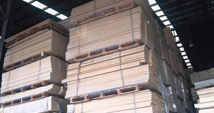 Background of neatly stacked square wooden beams in a lumberyard, wood factory. Close up of texture and ends of sawn timber blocks arranged in bundles. Rows of square cut wood planks stacked.