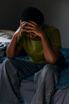 Frustrated woman sitting on bed at home