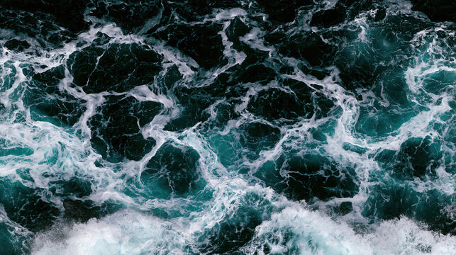 Aerial view of turquoise ocean waves with white foam, dark water