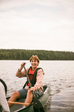 Portrait of female counselor doing boating activity in lake at summer camp