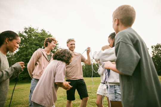 Group leaders holding rope while teaching survival skills to kids at summer camp