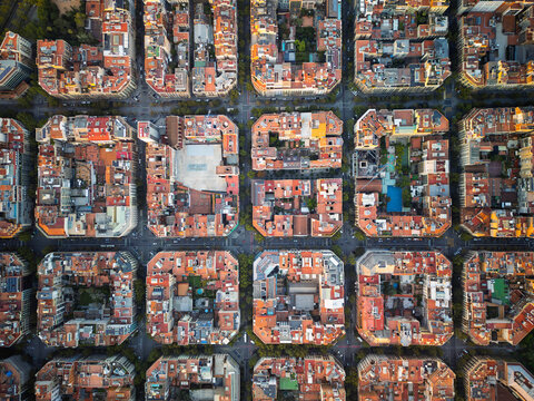Aerial view of the Eixample district featuring its iconic grid layout, octagonal city blocks, and terracotta rooftops in Barcelona, Catalonia, Spain.