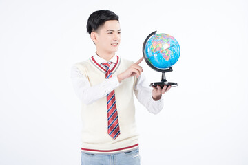 Fototapeta premium Smiling Student Holding and Pointing at a Globe in Uniform