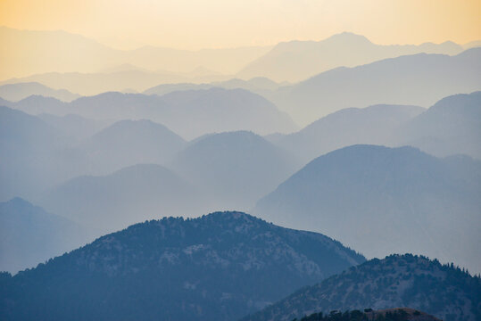 Twilight Over a Rugged Mountain Range with Deep Blue Foreground Peaks