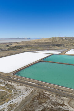 Aerial view of wastewater evaporation ponds by the Great Salt Lake with crystalized salt and crusted ground in Ogden, Utah, United States.