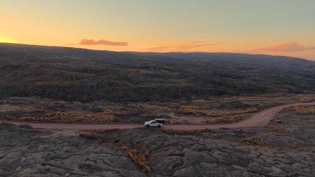 Drone view of offroad overland truck traveling through mountain trail during golden hour in Altas Cumbres Cordoba
