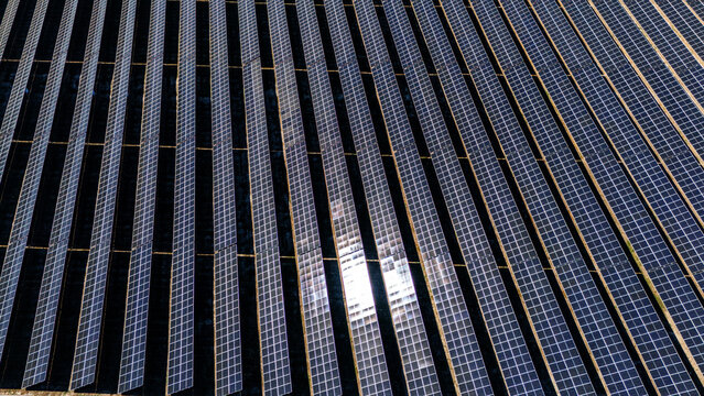 Aerial view of a large solar farm with rows of photovoltaic panels capturing sunlight in Temerin, Vojvodina, Serbia.