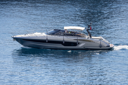 Aerial view of a sleek silver motor yacht cruising through the deep blue waters off the coast of Monaco City, Monaco, Monaco.