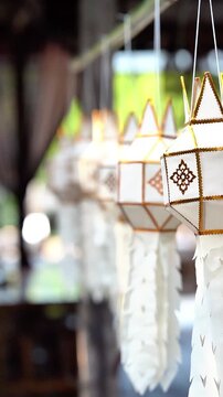 Traditional Lanna paper lanterns swaying in slow motion at Wat Ton Kwen, Chiang Mai, Thailand.