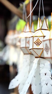 Traditional Lanna paper lanterns swaying in slow motion at Wat Ton Kwen, Chiang Mai, Thailand.