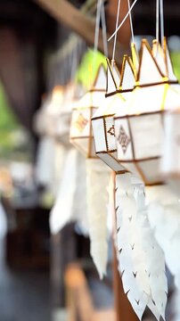 Traditional Lanna paper lanterns swaying in slow motion at Wat Ton Kwen, Chiang Mai, Thailand.