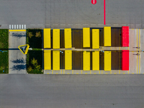 Aerial view of Logistikzentrum Allhaming with rows of yellow and red shipping containers in a paved logistics yard with marked parking spaces in Allhaming, Oberosterreich, Austria.