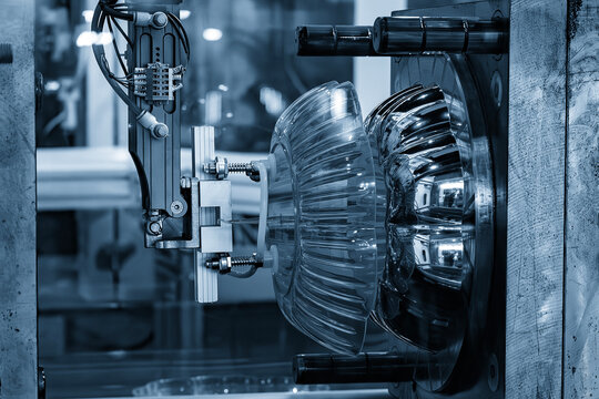 Mass production of high glossy plastic parts by an injection molding machine in a blue tone scene