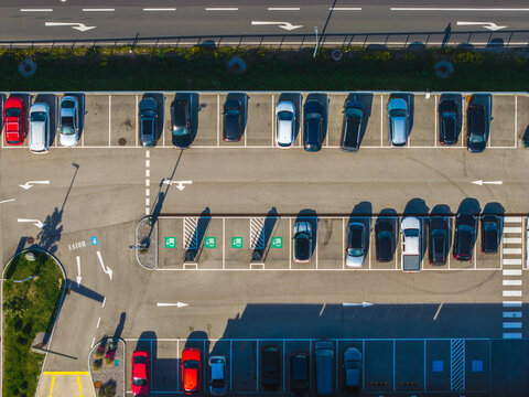 Aerial view of Logistikzentrum Allhaming with rows of parked cars in a paved parking lot, marked parking spaces, and road markings in Allhaming, Oberosterreich, Austria.