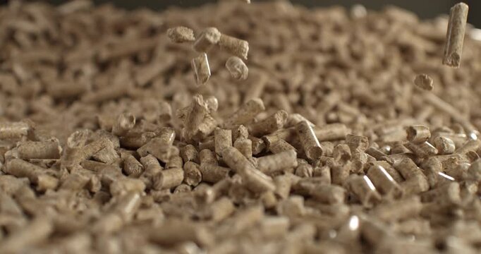 Wood pellets cascading onto a bed of pellets at 1000 fps, capturing dynamic impact and natural texture. Cinematic imagery symbolizing renewable energy, sustainability and a cleaner future.