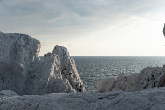 Scenic coastal landscape of white limestone rocks and calm sea under blue sky in Wakayama Japan