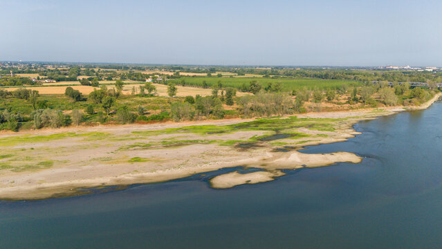 Aerial view of the Po River with low water levels caused by a summer heatwave, exposing sandy riverbeds and sediments along the banks Castelvetro Piacentino, Emilia-Romagna, Italy.