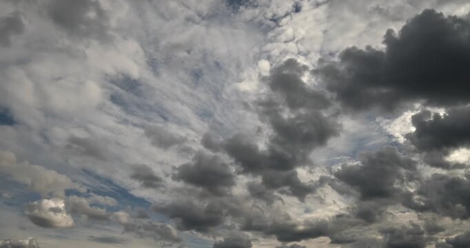 Beautiful dramatic time lapse of dark storm clouds moving fast across blue sky before rain