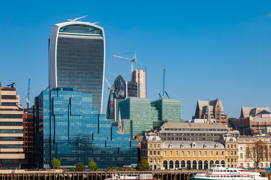 London city skyline featuring contemporary architecture, historic buildings, and boats on the river thames