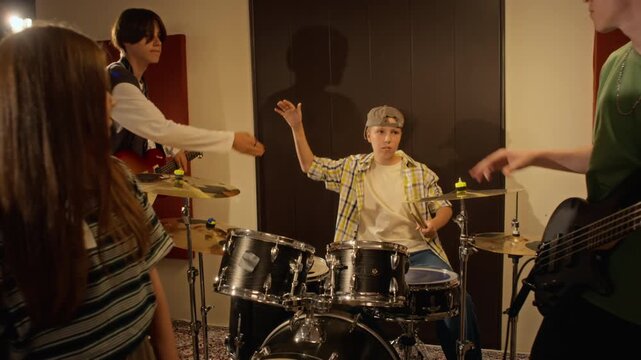 Multiethnic teenage musicians celebrating rehearsal finish with high fives in slow motion. Clip suitable for youth hobby promotions and music education projects