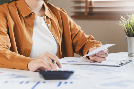 person using calculator calculating tax refund on the table