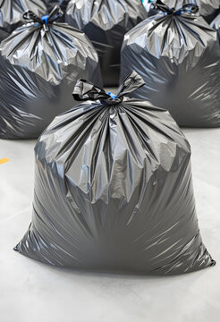 Waste management and environmental pollution, black plastic garbage bags filled with trash ready for collection and disposal in an industrial facility