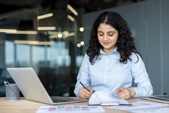 Businesswoman working on documents at office desk