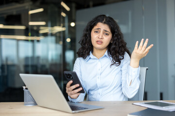 Confused young woman experiencing problem with smartphone