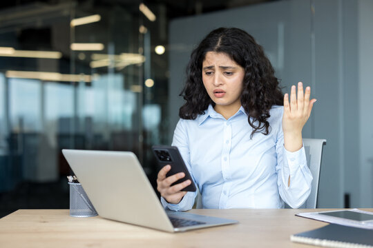 Businesswoman experiencing frustration with smartphone and technology issues