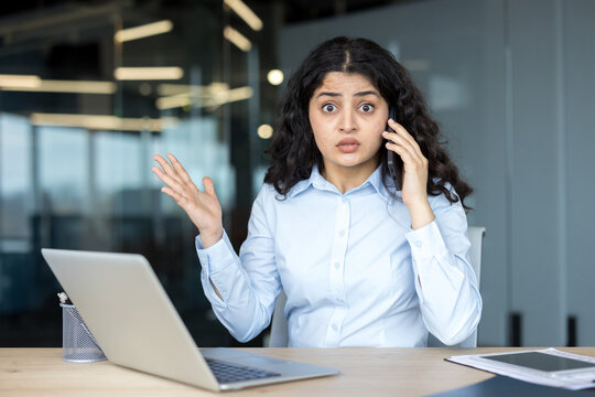 Businesswoman receiving surprising news during phone call at office