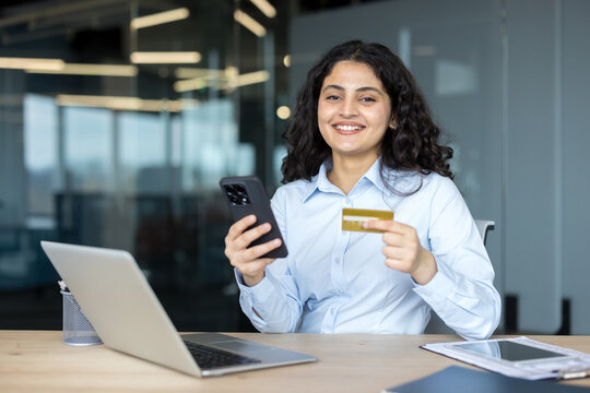 Woman holding phone and credit card doing online shopping