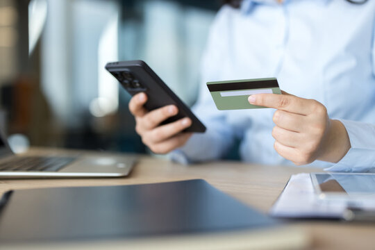 Person holding smartphone and credit card for online payment