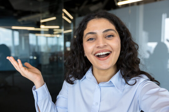 Happy businesswoman smiling and gesturing during video call in office