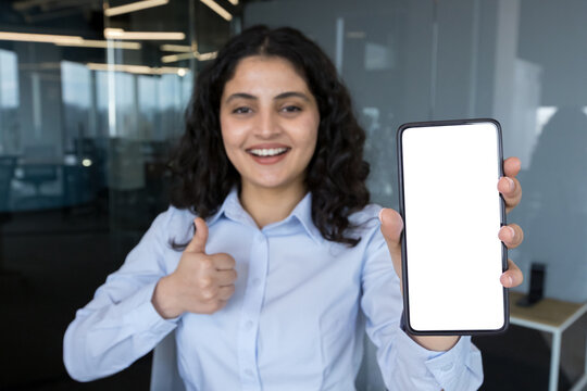 Young woman showing blank smartphone screen recommending application