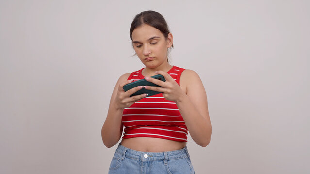 Seriouse Indian Teenage Girl Playing Game on Mobile Phone
