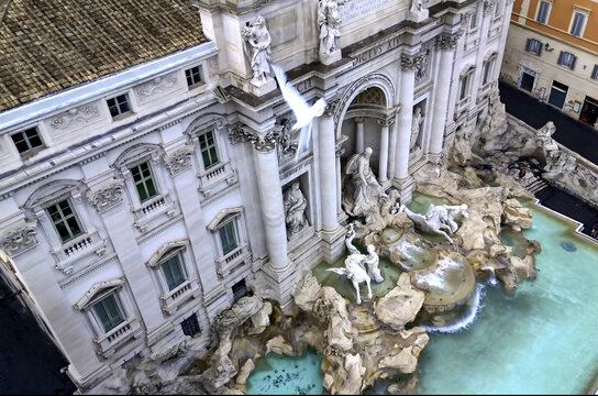 Rome, Italy - 28 June 2024: Aerial view of Trevi Fountain with its intricate baroque sculptures, turquoise water, and surrounding historic buildings in the city.
