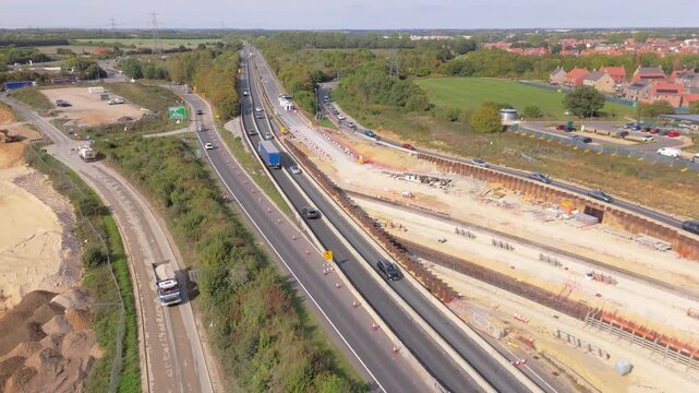 A forward drone push in movement above the roadworks at the Thickthorn Interchange in Norwich, UK showing the layout of the new lanes