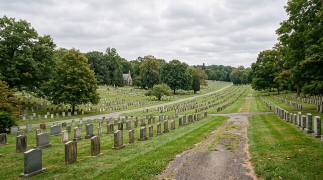 A peaceful view of a historic cemetery with rows of gravestones on a grassy hill.