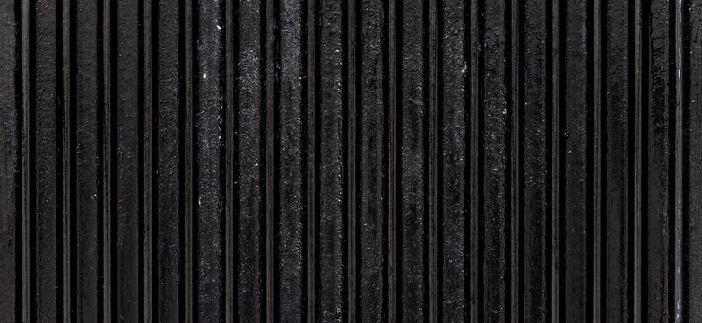 Black ribbed cast iron metal surface texture background