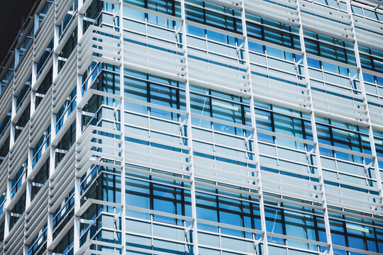 Modern architecture building facade featuring glass panels, steel frames, and horizontal sunshade louvers