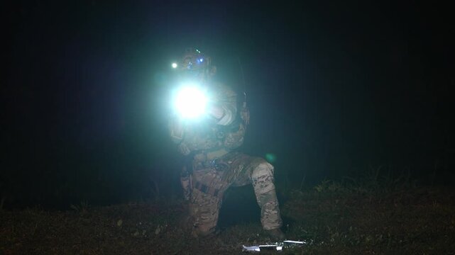 Night operations with special forces member using a flashlight in a