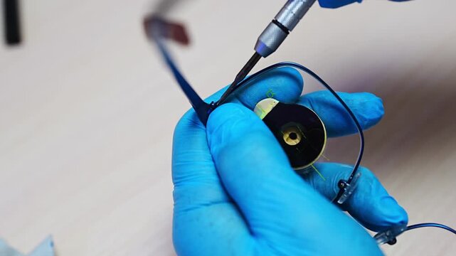Medical optician technician processing custom vision correction lenses