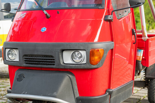 26 July 2026, Toblach, Italy. Red Piaggio Ape 50 three-wheeled utility vehicle in the Alpine town center