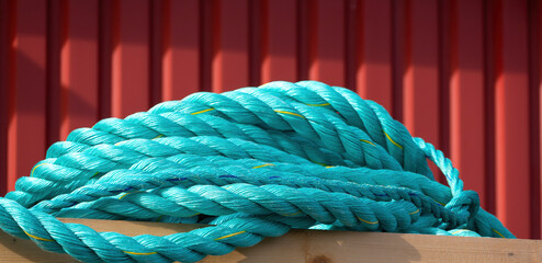 Title: Coiled turquoise rope for maritime and fishing applications © Comofoto