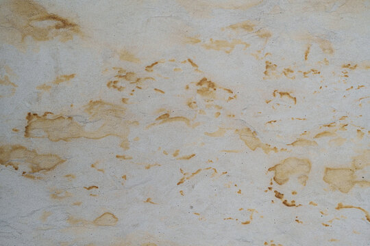 Textura de pared de concreto gris envejecido con manchas ocres, desgaste irregular y acabado vintage