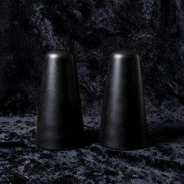 Minimalism and interior design, two matte black cone objects on dark velvet texture for luxury home decor and abstract artistic composition