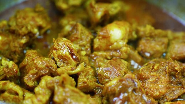Close-up of tender meat in rich spiced curry, Tender meat pieces simmered in rich golden brown curry sauce, showing a flavorful homemade dish with warm spices and glossy gravy