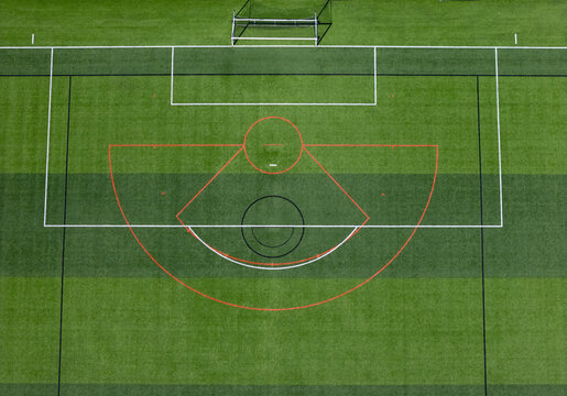 Aerial view of a soccer field featuring white boundary lines, a red arc, and a black center circle on green artificial turf in Kalamazoo, Michigan, United States.